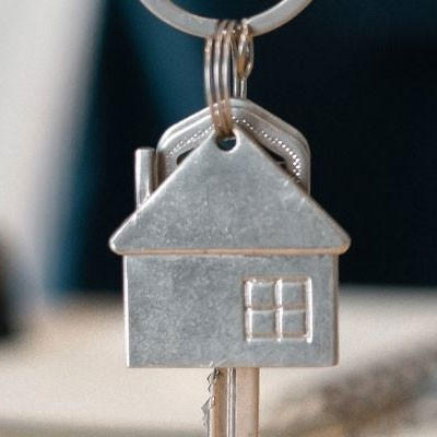 Trousseau de clés avec un porte-clés en forme de maison métallique stylisée.